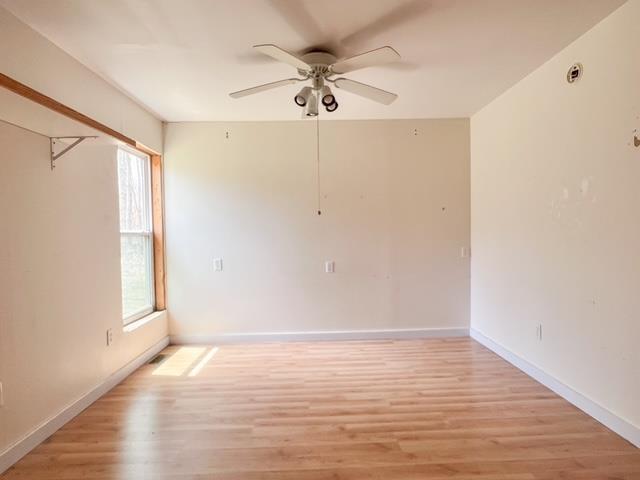 1300 Birch Rd, Harrison, MI 48625 - unfurnished room featuring baseboards, a ceiling fan, and light wood finished floors