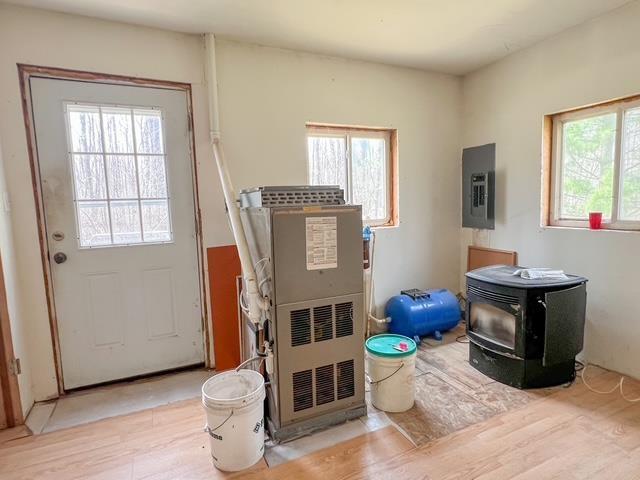 1300 Birch Rd, Harrison, MI 48625 - doorway with electric panel, a wood stove, and wood finished floors