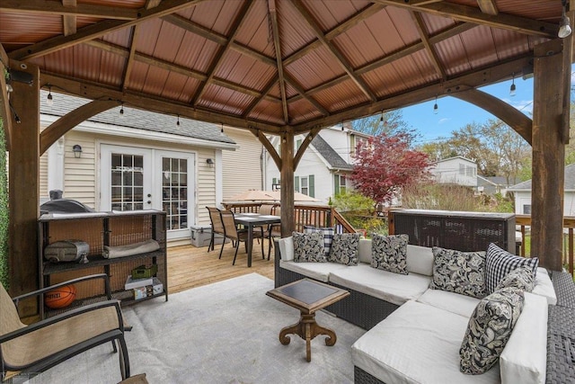 view of patio / terrace featuring a gazebo, an outdoor hangout area, a wooden deck, outdoor dining area, and french doors