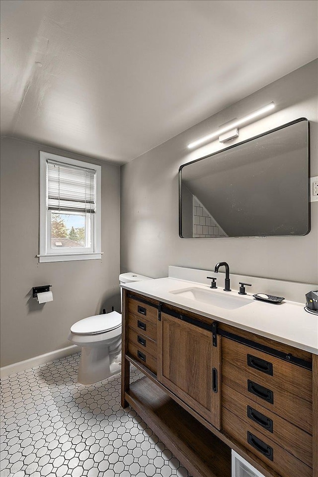 bathroom featuring toilet, baseboards, lofted ceiling, and vanity