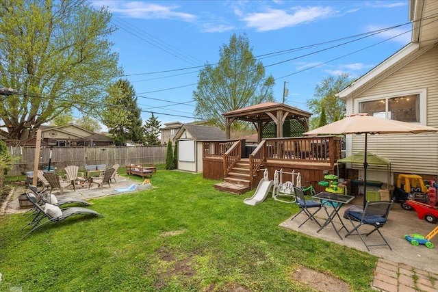 view of yard featuring fence, a storage unit, a gazebo, a patio area, and an outdoor structure