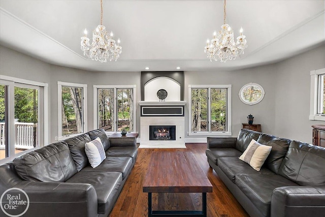 living room with dark wood finished floors, a chandelier, and a healthy amount of sunlight