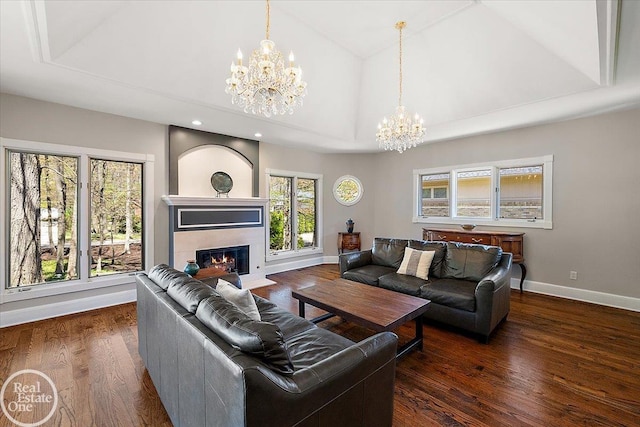 living area with a tiled fireplace, wood finished floors, baseboards, a chandelier, and recessed lighting