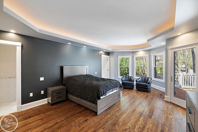 bedroom featuring a raised ceiling, baseboards, recessed lighting, and wood finished floors