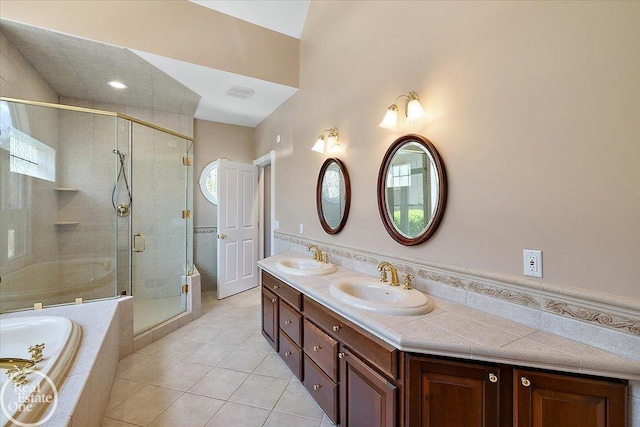 full bathroom with double vanity, a bath, a shower stall, a sink, and tile patterned floors