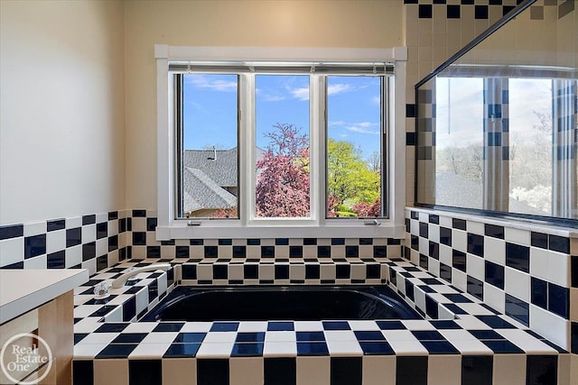 interior space with a garden tub and tasteful backsplash