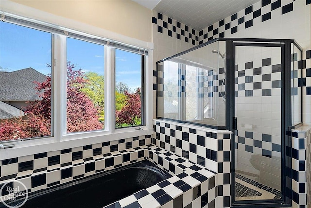 bathroom with a shower stall and a wealth of natural light