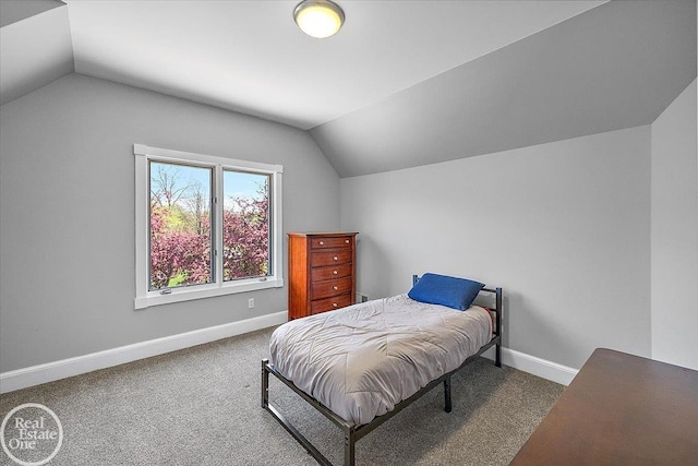 carpeted bedroom with baseboards and lofted ceiling