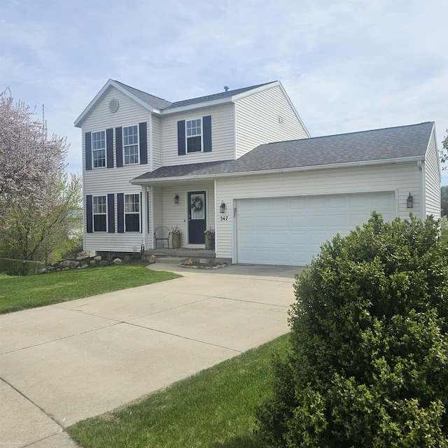 traditional-style home with a garage, concrete driveway, and a front yard
