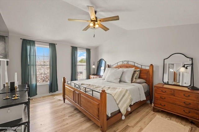 bedroom with ceiling fan, lofted ceiling, baseboards, and light wood finished floors