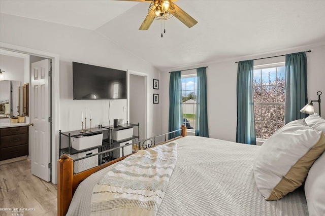 bedroom featuring ensuite bathroom, light wood finished floors, ceiling fan, and lofted ceiling