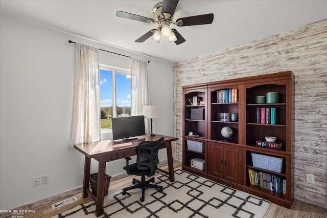 office with visible vents, a ceiling fan, light wood finished floors, and wallpapered walls