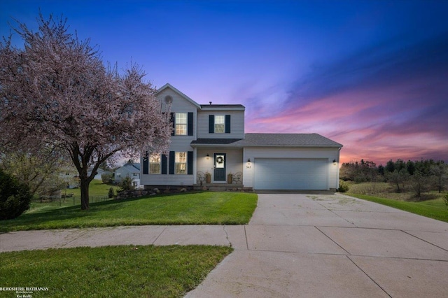traditional home featuring a yard, driveway, and a garage