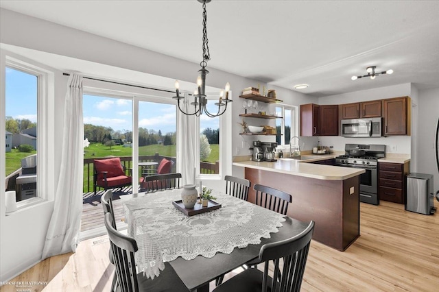 dining area featuring an inviting chandelier, light wood finished floors, and a wealth of natural light