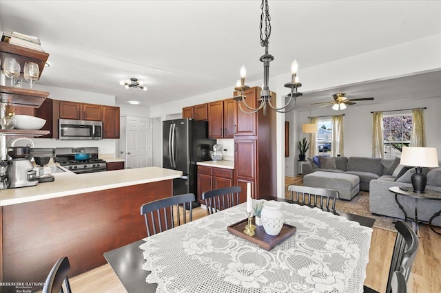 dining space with ceiling fan and light wood-style flooring