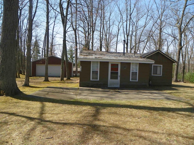 ranch-style house with a detached garage, metal roof, and an outdoor structure