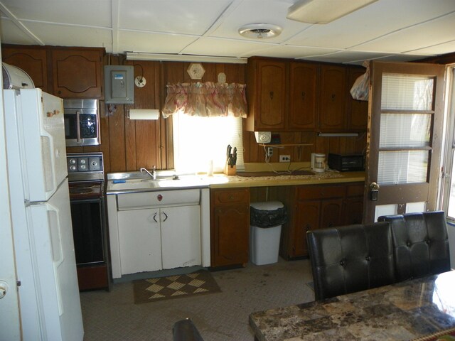 kitchen featuring visible vents, freestanding refrigerator, stainless steel microwave, a sink, and range