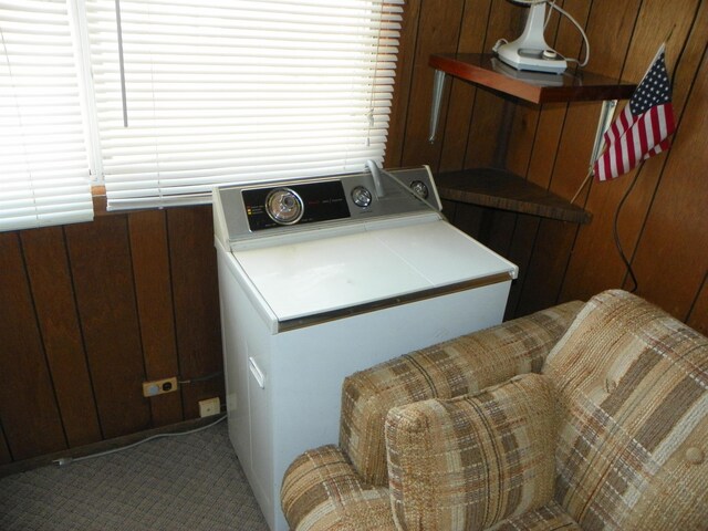 laundry room featuring laundry area, wood walls, carpet, and washer / clothes dryer