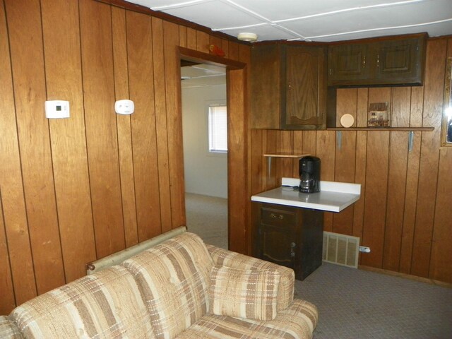 carpeted bedroom featuring visible vents and wooden walls