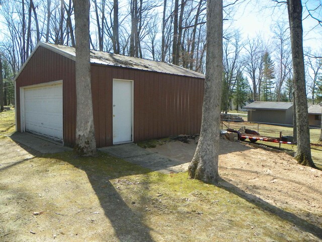 detached garage featuring fence and driveway