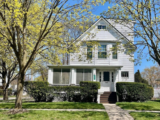 706 W Indiana St, Bay City, MI 48706 - victorian-style house featuring a sunroom and a front lawn