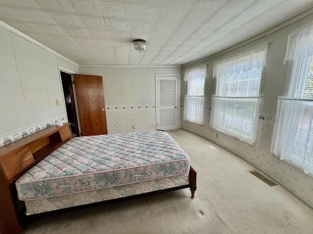 706 W Indiana St, Bay City, MI 48706 - carpeted bedroom with visible vents, ornamental molding, and a closet