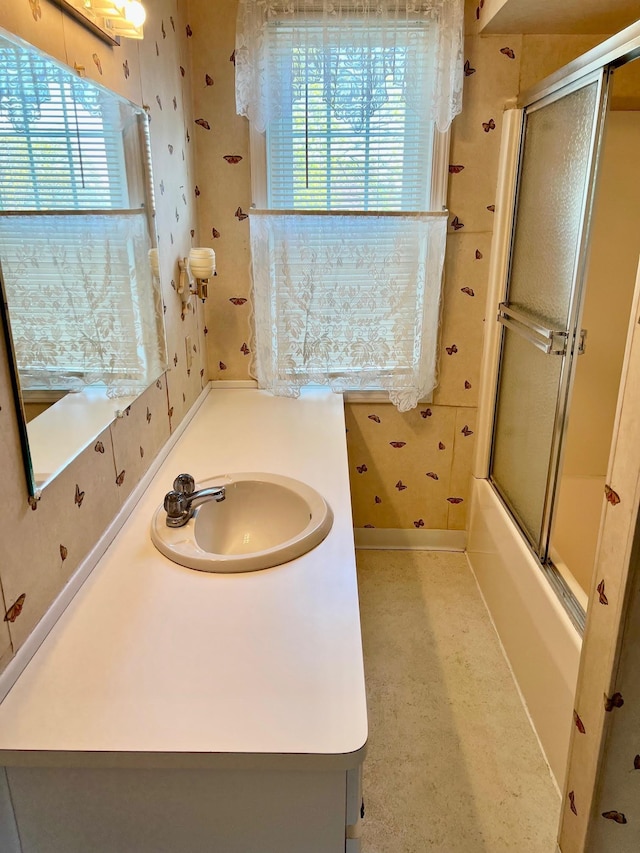 706 W Indiana St, Bay City, MI 48706 - bathroom with wallpapered walls, plenty of natural light, bath / shower combo with glass door, and vanity