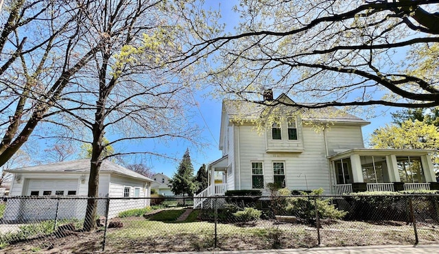 706 W Indiana St, Bay City, MI 48706 - italianate-style house with a sunroom, an outdoor structure, a fenced front yard, and a chimney