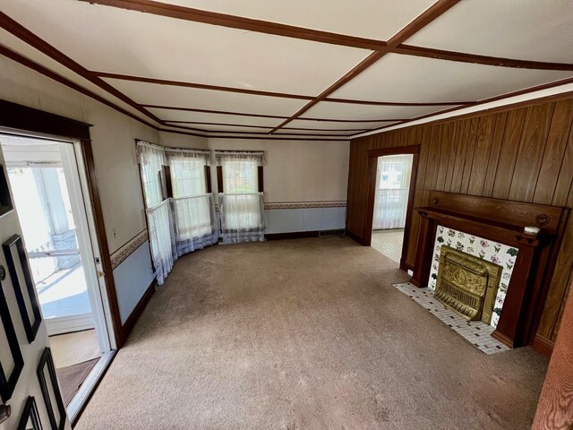 706 W Indiana St, Bay City, MI 48706 - unfurnished living room with carpet floors, wood walls, and a fireplace with flush hearth