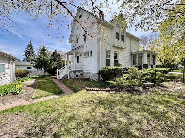 706 W Indiana St, Bay City, MI 48706 - view of property exterior featuring a lawn, fence, a chimney, and a sunroom