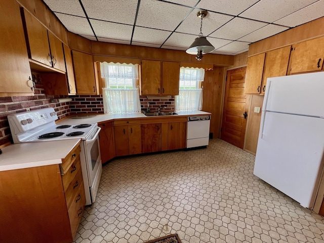 706 W Indiana St, Bay City, MI 48706 - kitchen featuring wood walls, white appliances, light countertops, brown cabinets, and a sink