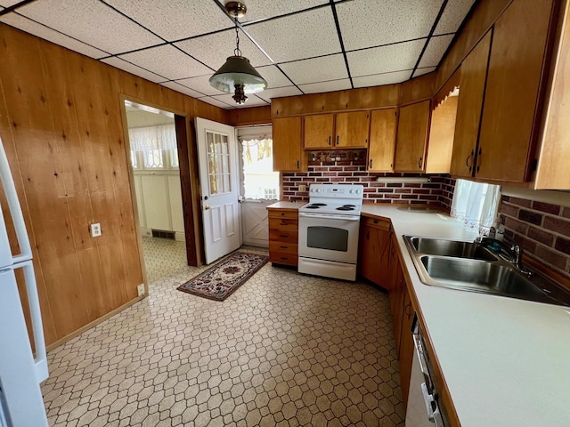 706 W Indiana St, Bay City, MI 48706 - kitchen featuring white range with electric stovetop, hanging light fixtures, a sink, light countertops, and brown cabinetry