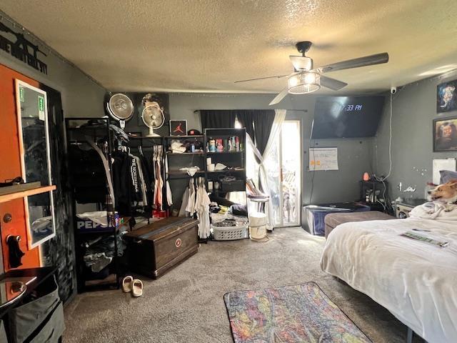 bedroom featuring carpet, a ceiling fan, and a textured ceiling