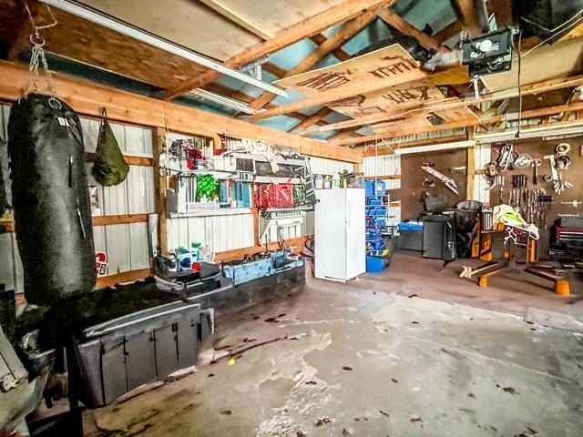 below grade area featuring freestanding refrigerator and a garage