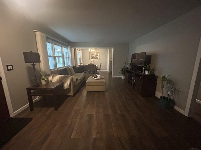 living room with dark wood-type flooring and baseboards