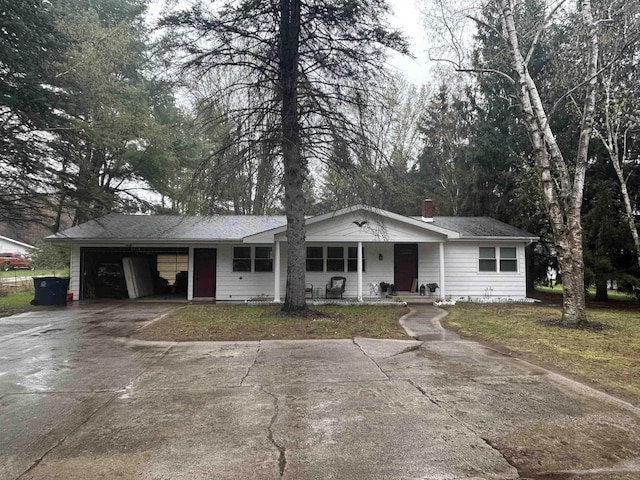 ranch-style house featuring covered porch, a chimney, and concrete driveway