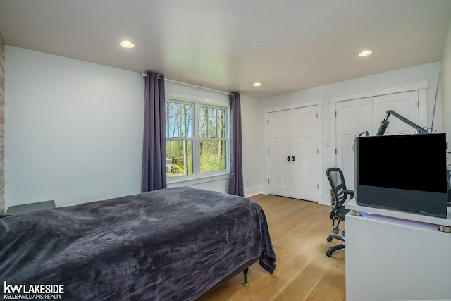 bedroom featuring recessed lighting, multiple closets, and light wood-type flooring