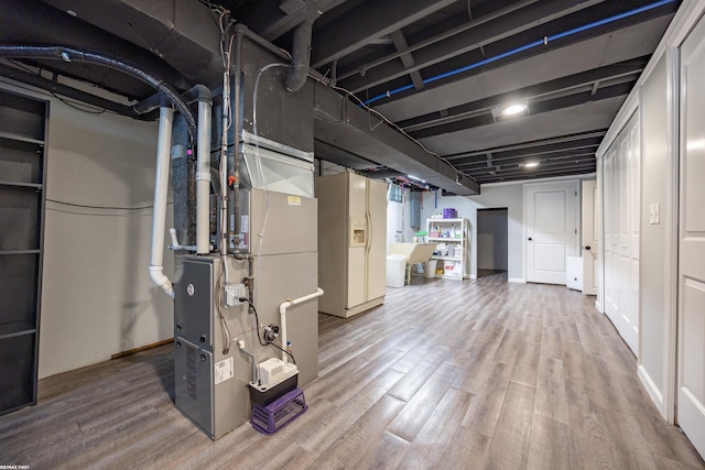 finished basement featuring heating unit and wood finished floors