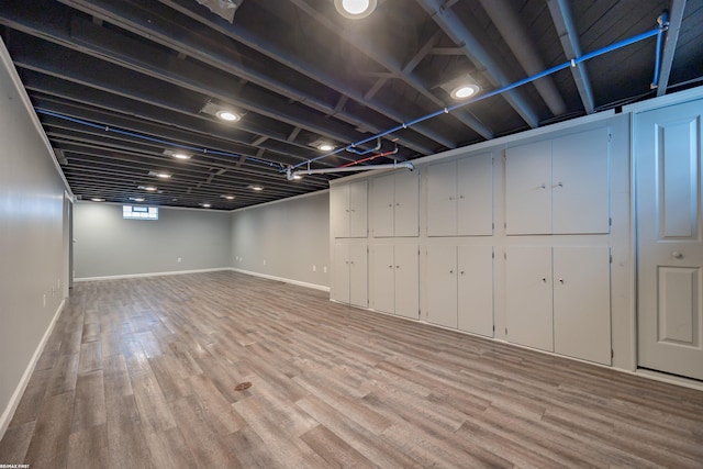 below grade area featuring baseboards and light wood-type flooring