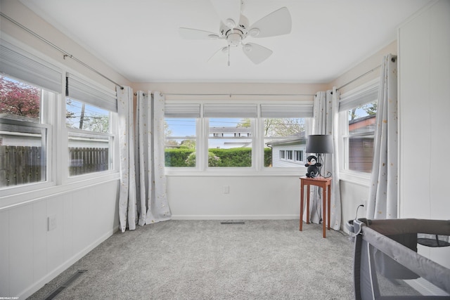 sunroom featuring carpet floors, baseboards, and visible vents