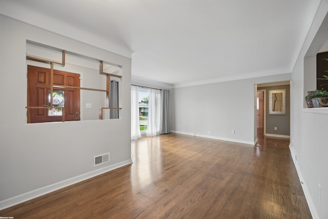 unfurnished room with baseboards, wood finished floors, and visible vents