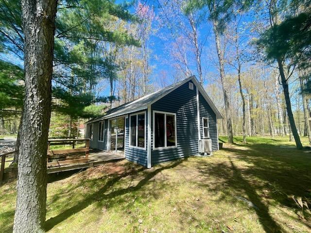 view of property exterior with a yard and a deck