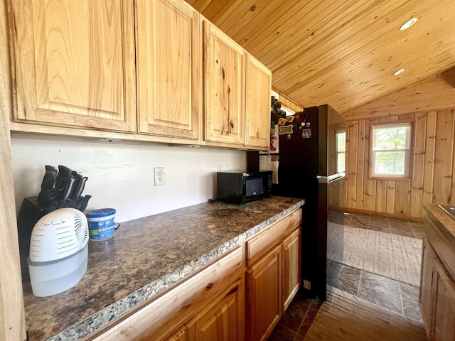 1548 Pioneer Rd, Alger, MI 48610 - kitchen with black microwave, dark countertops, wood walls, freestanding refrigerator, and lofted ceiling