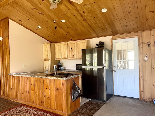 kitchen with freestanding refrigerator, a peninsula, dark countertops, wood ceiling, and a sink