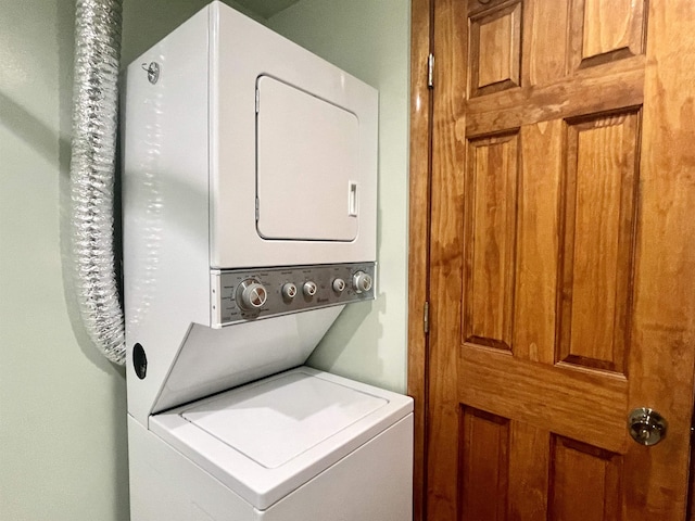 washroom featuring stacked washer / drying machine and laundry area