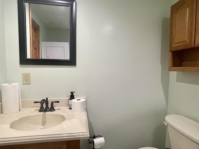 half bathroom with vanity and toilet