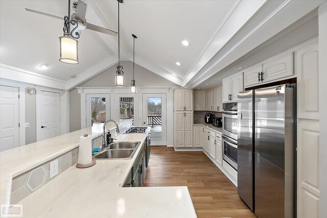 455 Garfield Rd, Fostoria, MI 48435 - kitchen with dark wood-style flooring, hanging light fixtures, appliances with stainless steel finishes, lofted ceiling with beams, and a sink