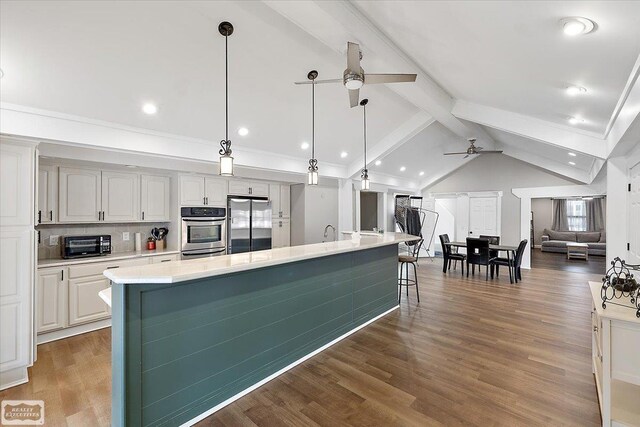 455 Garfield Rd, Fostoria, MI 48435 - kitchen featuring a ceiling fan, a large island with sink, white cabinets, vaulted ceiling with beams, and stainless steel appliances