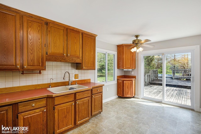36870 Hebel Rd, Richmond Twp, MI 48062 - kitchen with brown cabinetry, a sink, and backsplash