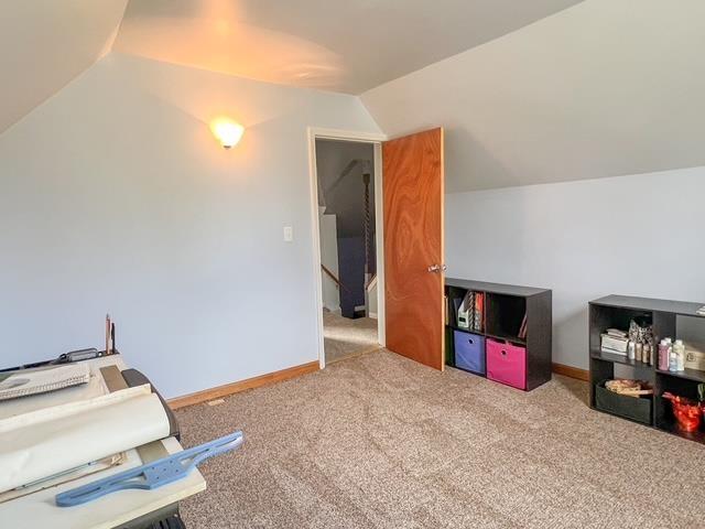 recreation room with carpet floors, baseboards, and lofted ceiling